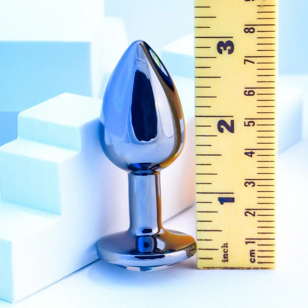 Chrome TUX butt plug beside a ruler, measuring just under 3 inches