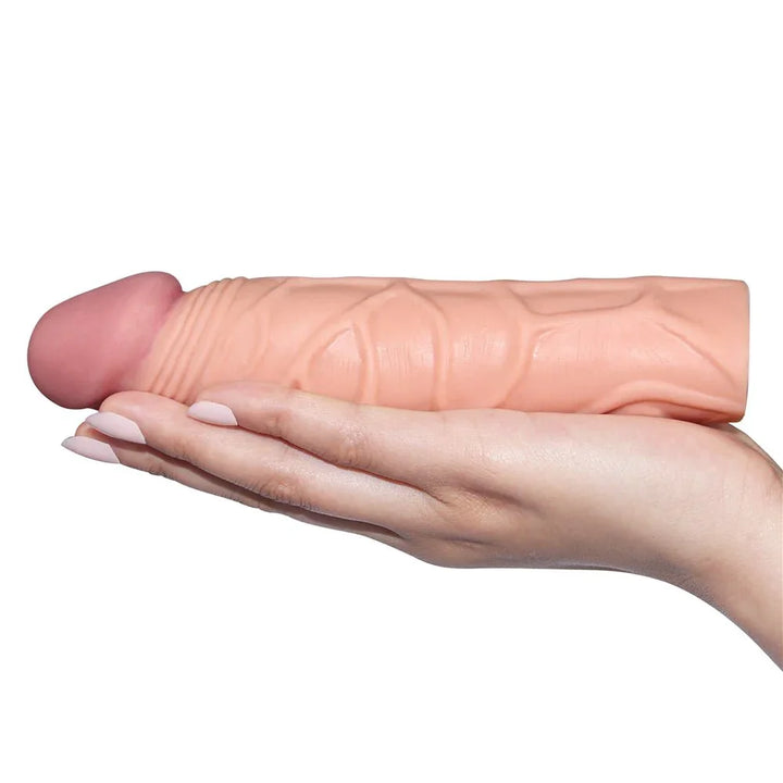 Pleasure X-Tender 1 inch sleeve lying across an open hand for scale