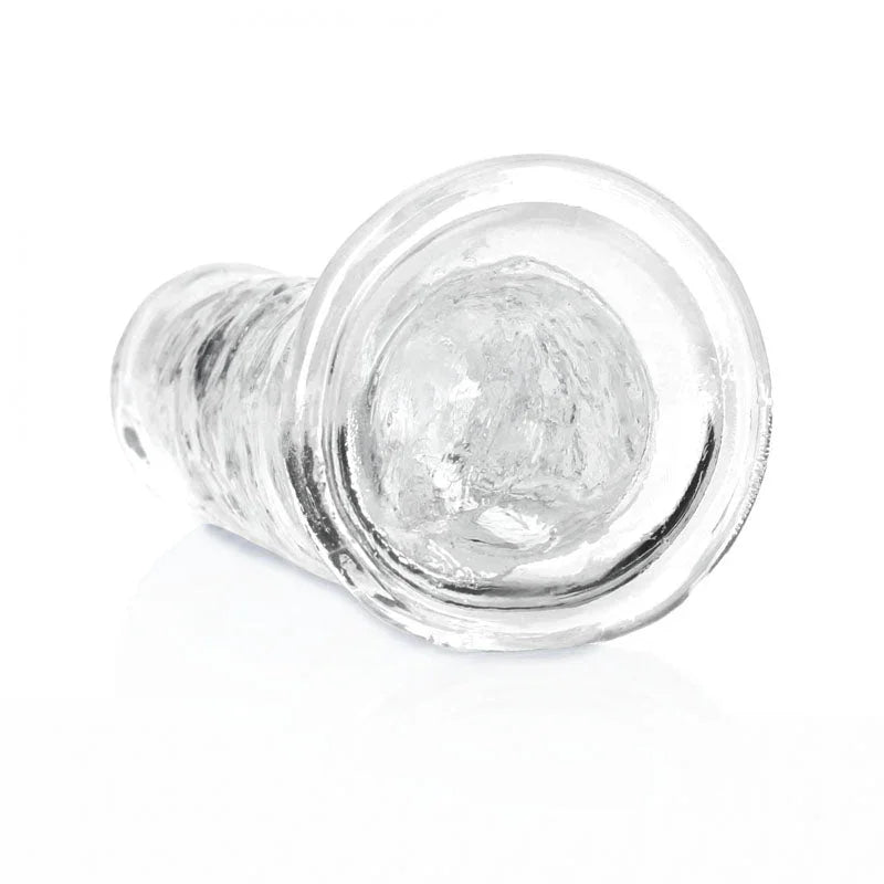 REALROCK 18 cm Straight Dildo in Clear, lying down with the suction base facing the camera
