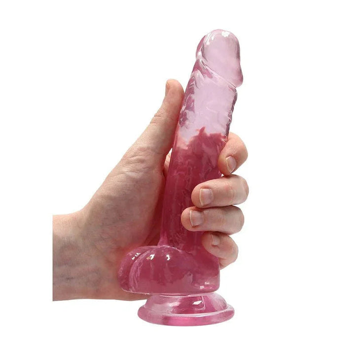 REALROCK 17.8 cm Realistic Dildo with Balls in Pink, held in one hand to show its girth