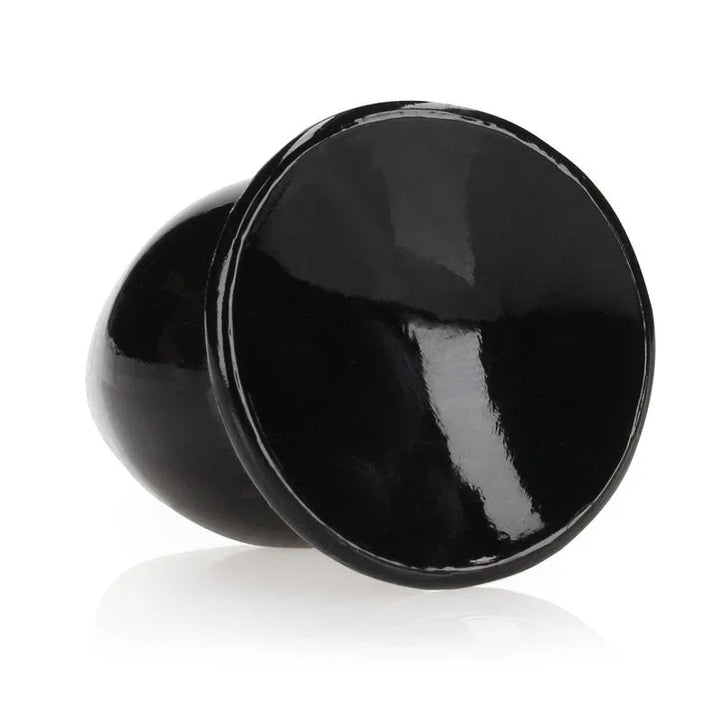 REALROCK 9 cm Anal Plug in Black, tipped over so the flared base faces the camera