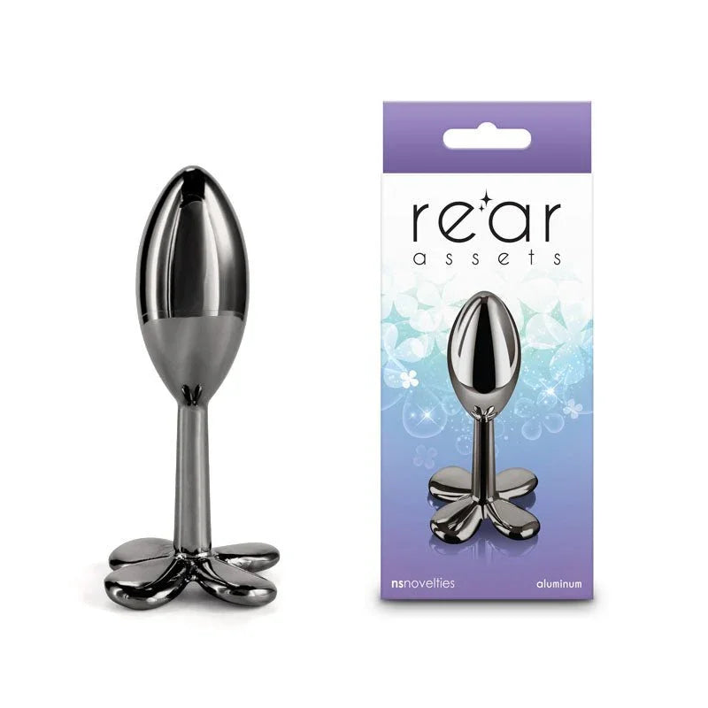 Rear Assets Clover metal butt plug in Gunmetal, dark clover base, beside its box