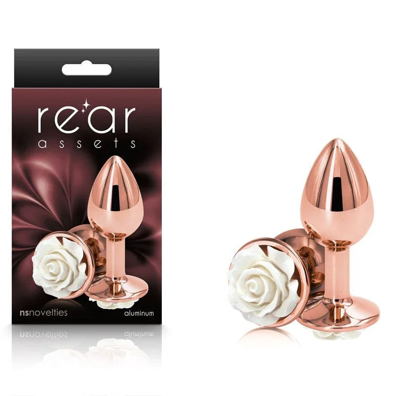 Rear Assets Rose plug in Rose Gold with a white rose base, beside its Rear Assets box
