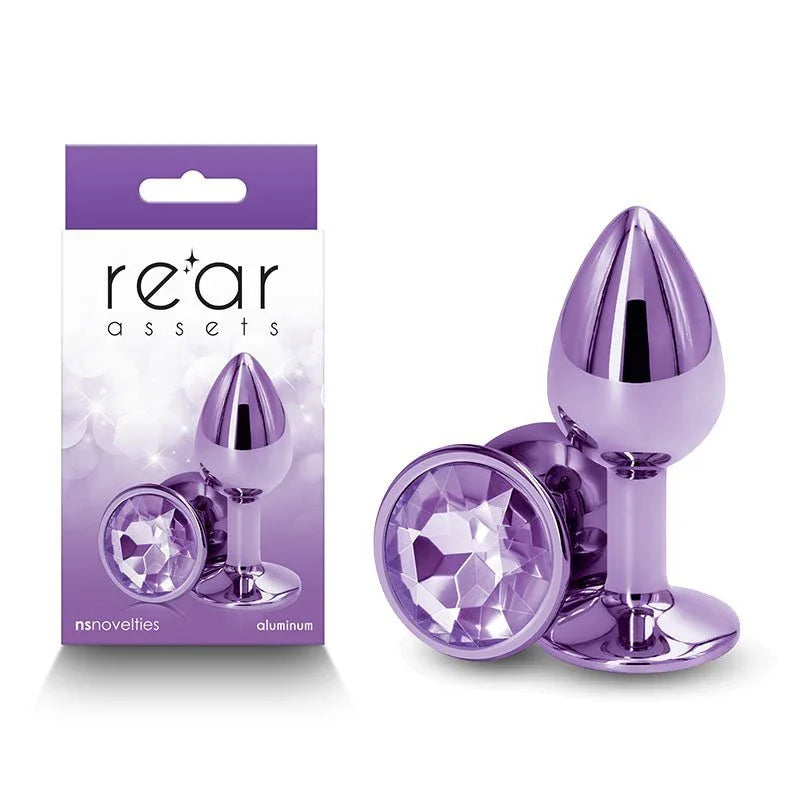 Rear Assets small metal butt plug in Purple with a purple round gem base, beside its box