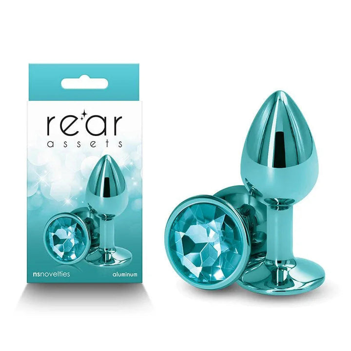 Rear Assets small metal butt plug in Teal with a teal round gem base, beside its box