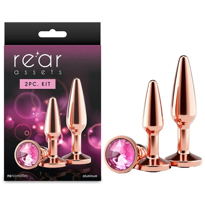 Rear Assets Tapered Trainer Kit in Rose Gold, two plugs and pink gem beside the 2pc box