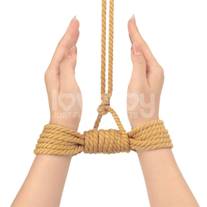 Wrists tied with natural rope and raised by a suspension line above