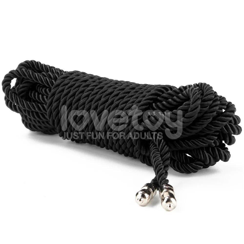 Hank of black silky bondage rope on white, both metal-tipped ends together