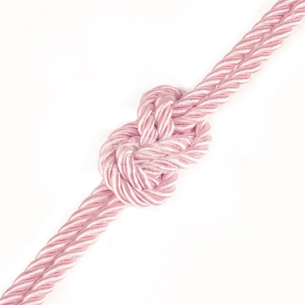 Knot tied in the pink silky rope, showing the satin sheen of the twist