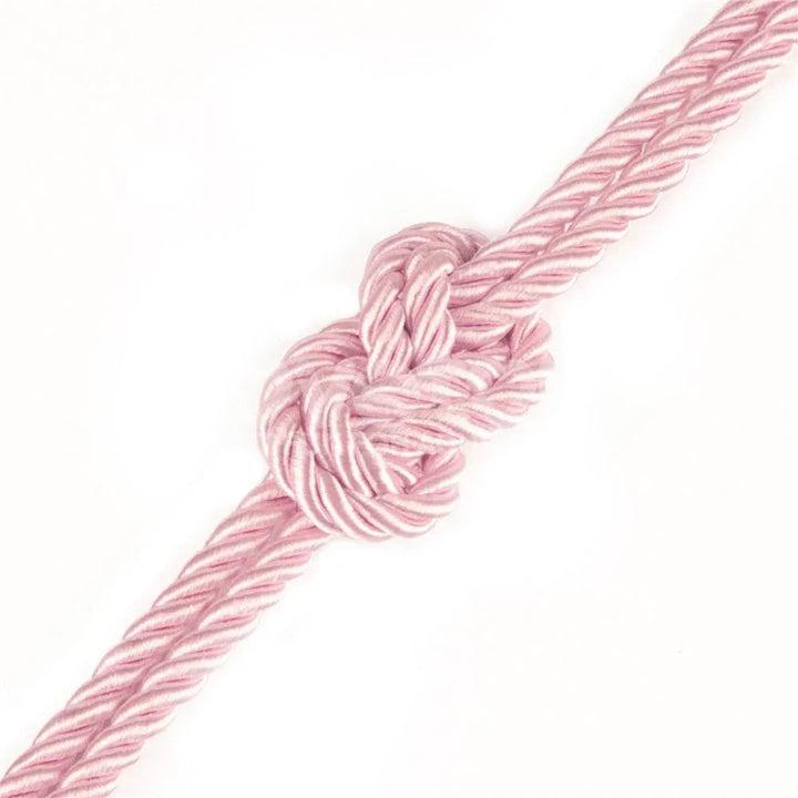 Knot tied in the pink silky rope, showing the satin sheen of the twist