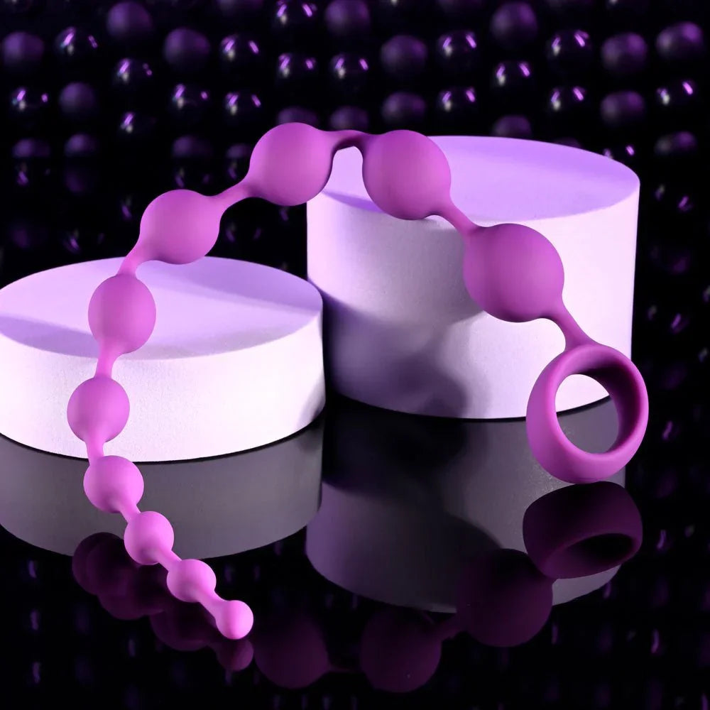 Purple Beaded Adventure beads draped over white plinths, pull ring at the right