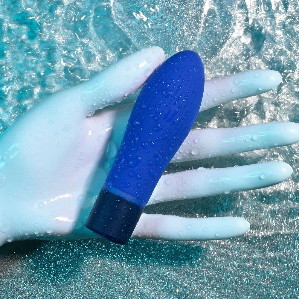 Cobalt Cutie bullet resting on a wet hand in rippling water