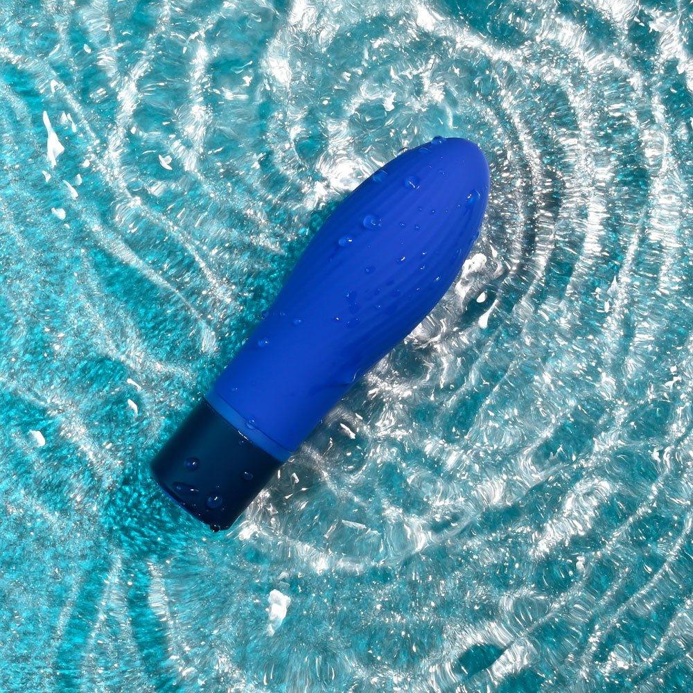 Cobalt Cutie half submerged in rippling water, showing it is waterproof