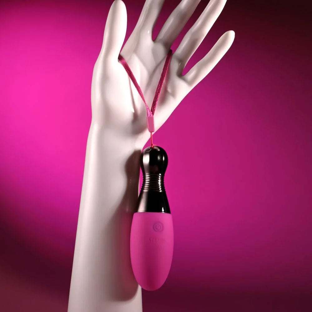 Companion egg hanging by its wrist cord from a white mannequin hand