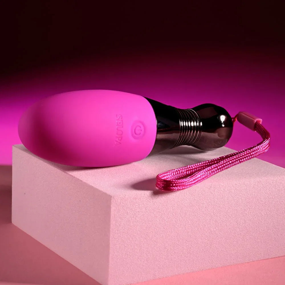 Companion egg lying flat on a pink plinth with the cord trailing
