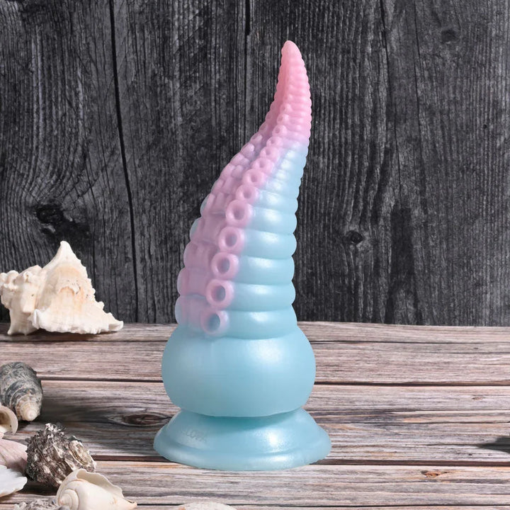 Stuck On You tentacle dildo standing upright on weathered wood among shells