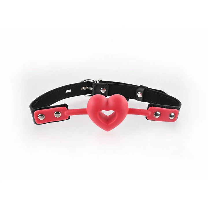 Amor Ball Gag laid out, red silicone heart on a black strap with red keepers