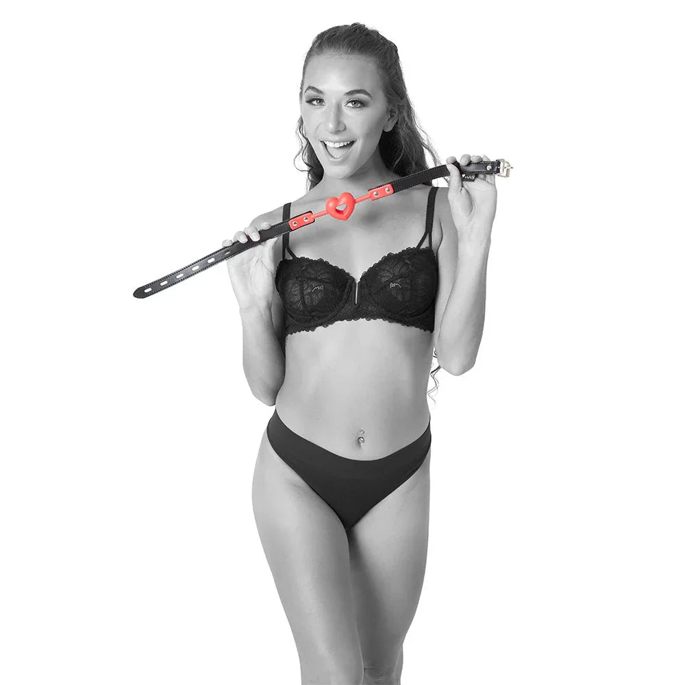 Model in lingerie holding the Amor Ball Gag over her shoulder