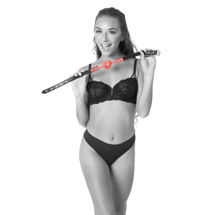 Model in lingerie holding the Amor Ball Gag over her shoulder