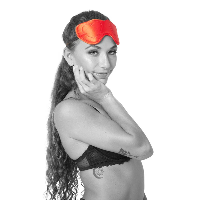 Model in a black bra with the red Amor Blindfold pushed up on her forehead