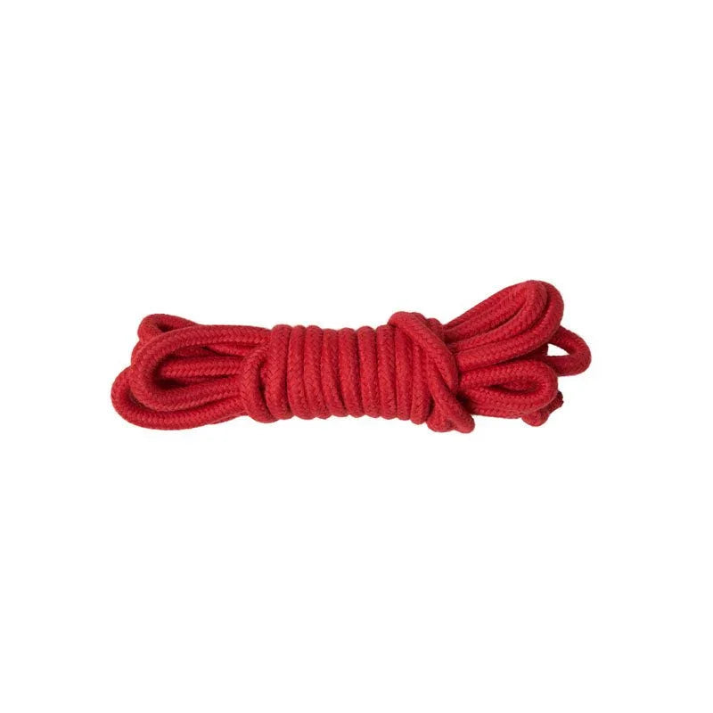 A single hank of red cotton bondage rope coiled on white