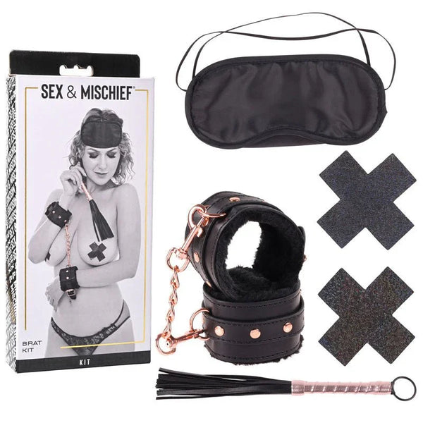 Sex & Mischief Brat Kit box beside the blindfold, fur-lined cuffs, cross pasties and mini flogger