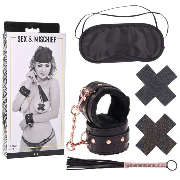 Sex & Mischief Brat Kit box beside the blindfold, fur-lined cuffs, cross pasties and mini flogger