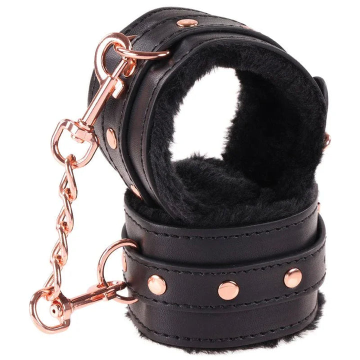 Close-up of the black fur-lined Brat cuffs with rose gold clips and chain