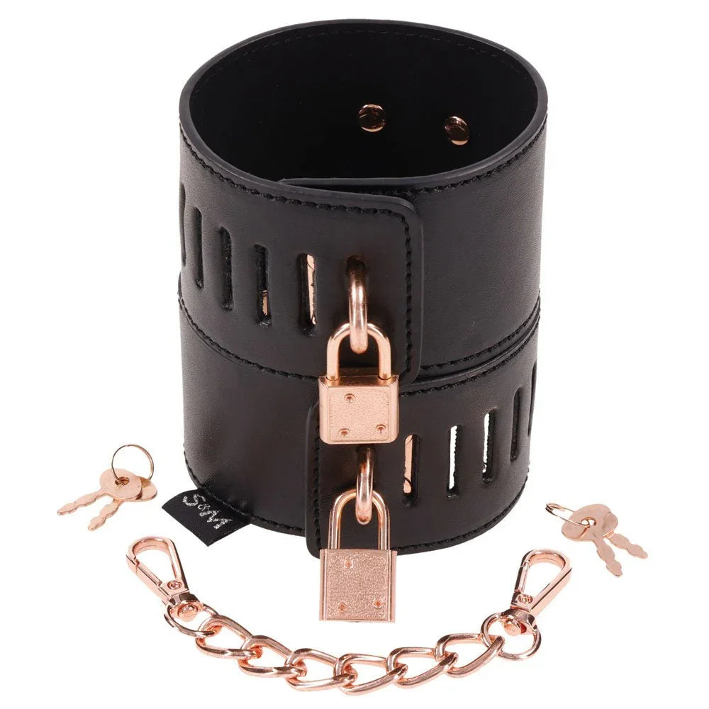 A single Brat locking cuff shown with two rose gold padlocks, the linking chain and its keys