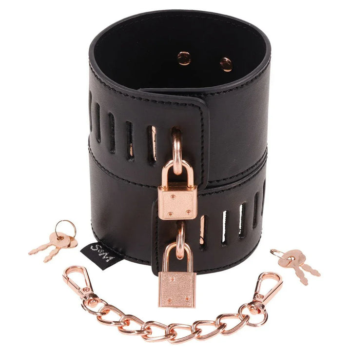 A single Brat locking cuff shown with two rose gold padlocks, the linking chain and its keys