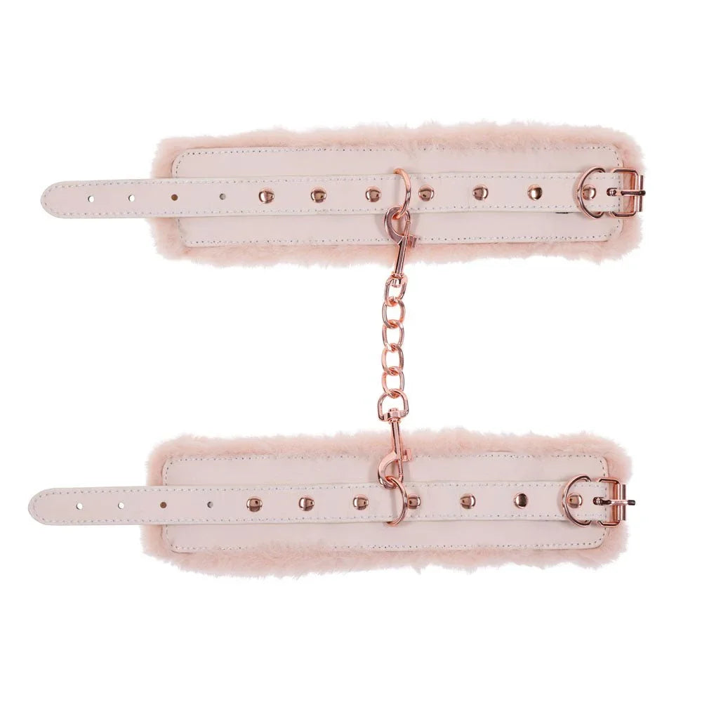 Fur handcuffs laid open flat with the rose gold chain running between them
