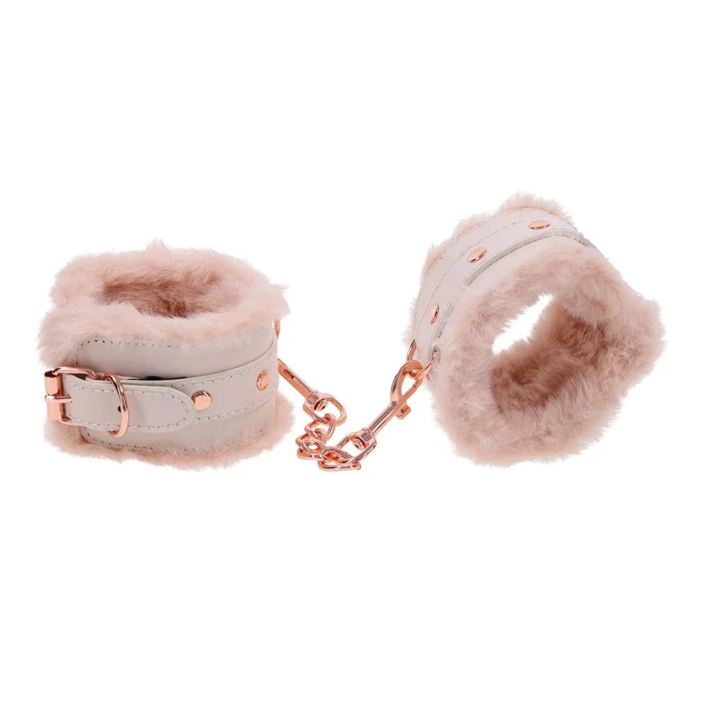 Fur handcuffs angled to show the peach fur trim and rose gold rivets