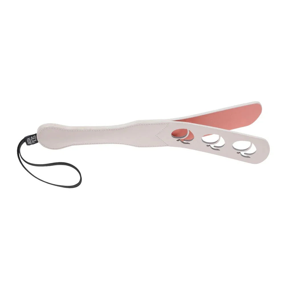 Impression paddle seen edge-on, coral inner layer visible behind the cut-outs