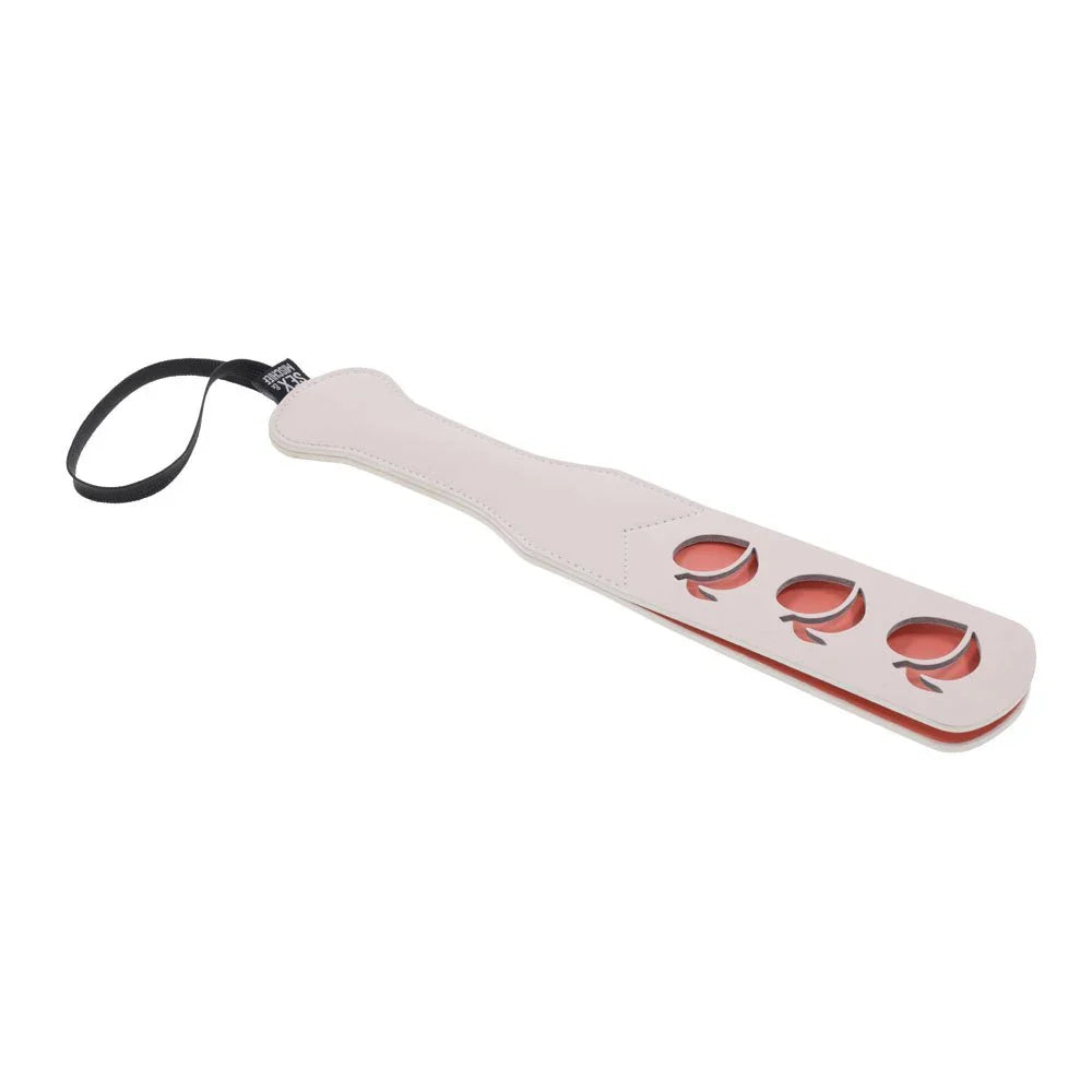 Peach impression paddle laid diagonally with the wrist loop at the handle