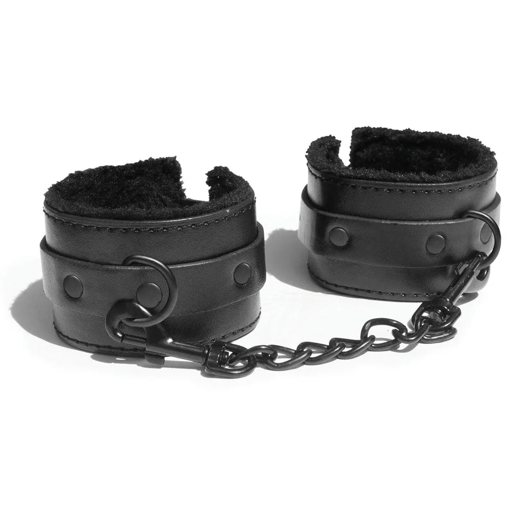 Black fur-lined handcuffs standing side by side, joined by a black chain