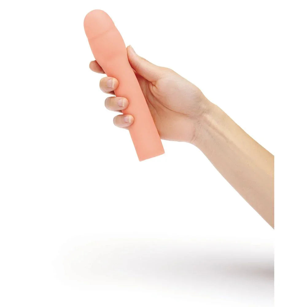 A hand holding the flesh Size Up 2 inch realistic extender upright