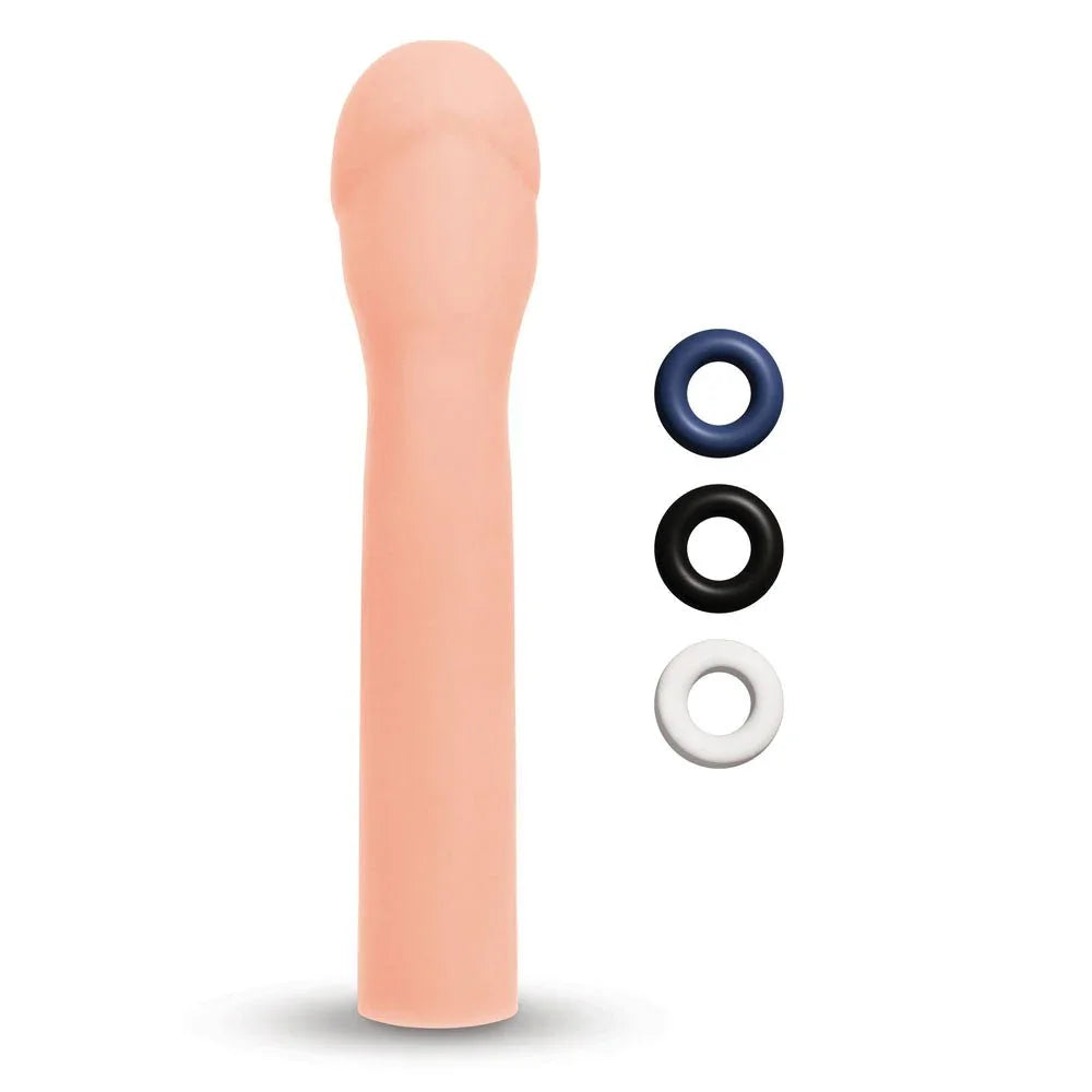 Size Up 3 inch realistic extender in Flesh upright beside blue, black and white rings