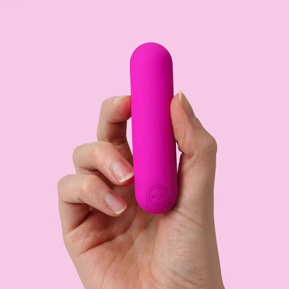 Super Excite bullet in Pink held in a hand against a pink backdrop