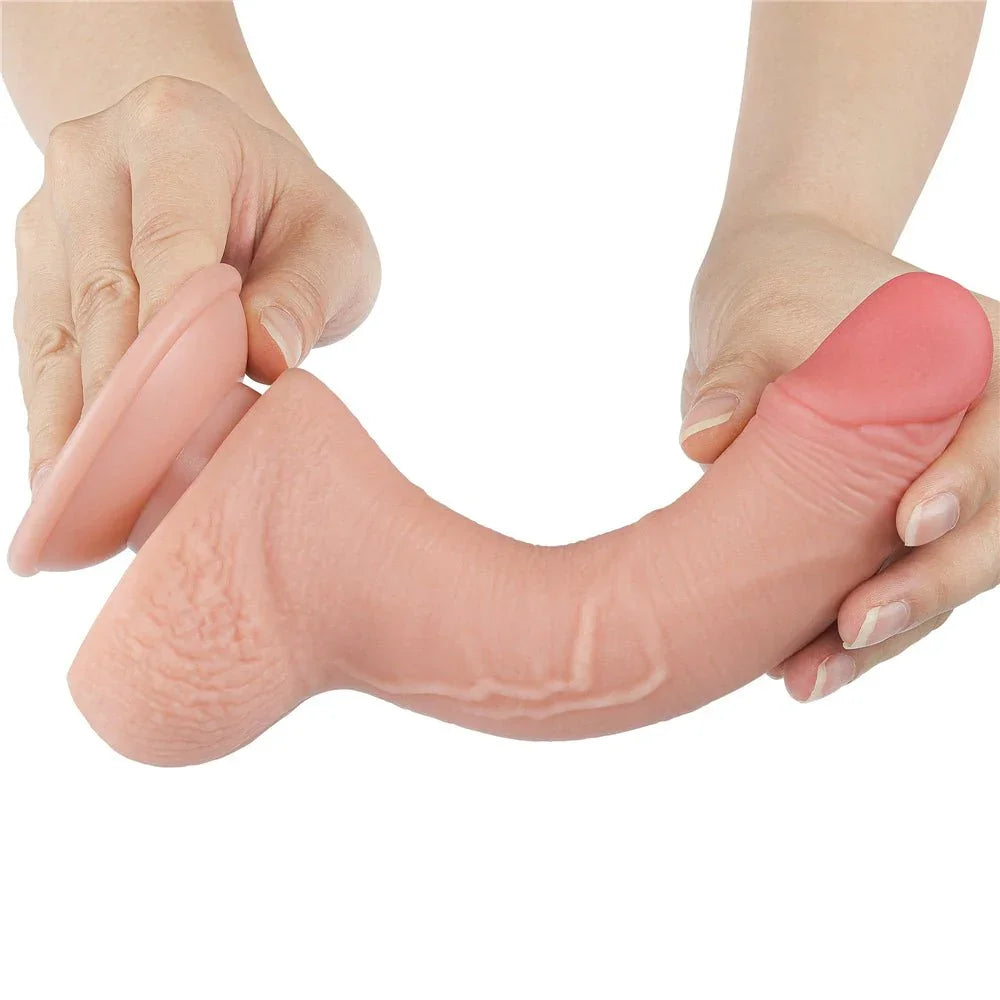 Two hands bending the Sliding Skin dong over, base held flat in one palm