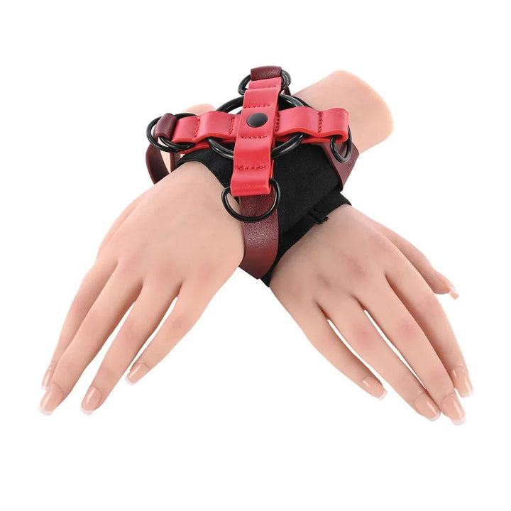 Mannequin wrists crossed and bound in the red and black X-shaped cuff