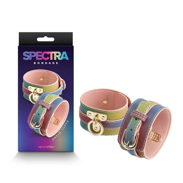 Spectra Bondage ankle cuffs in rainbow gradient with gold buckles, beside their box