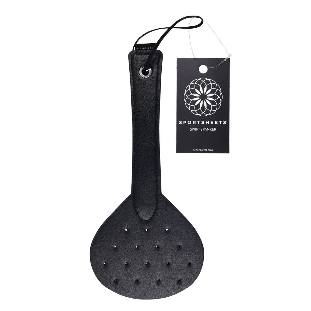 Sportsheets Swift Spanker hanging with its tag, round black blade with studs