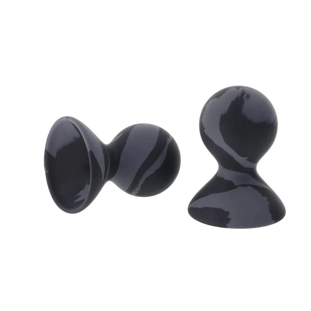 One nipple sucker lying on its side beside the other standing upright