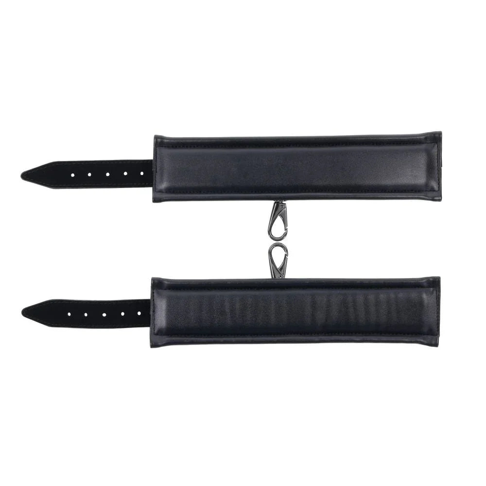 Two black quilted Velvet Noir wrist cuffs laid flat with their clip