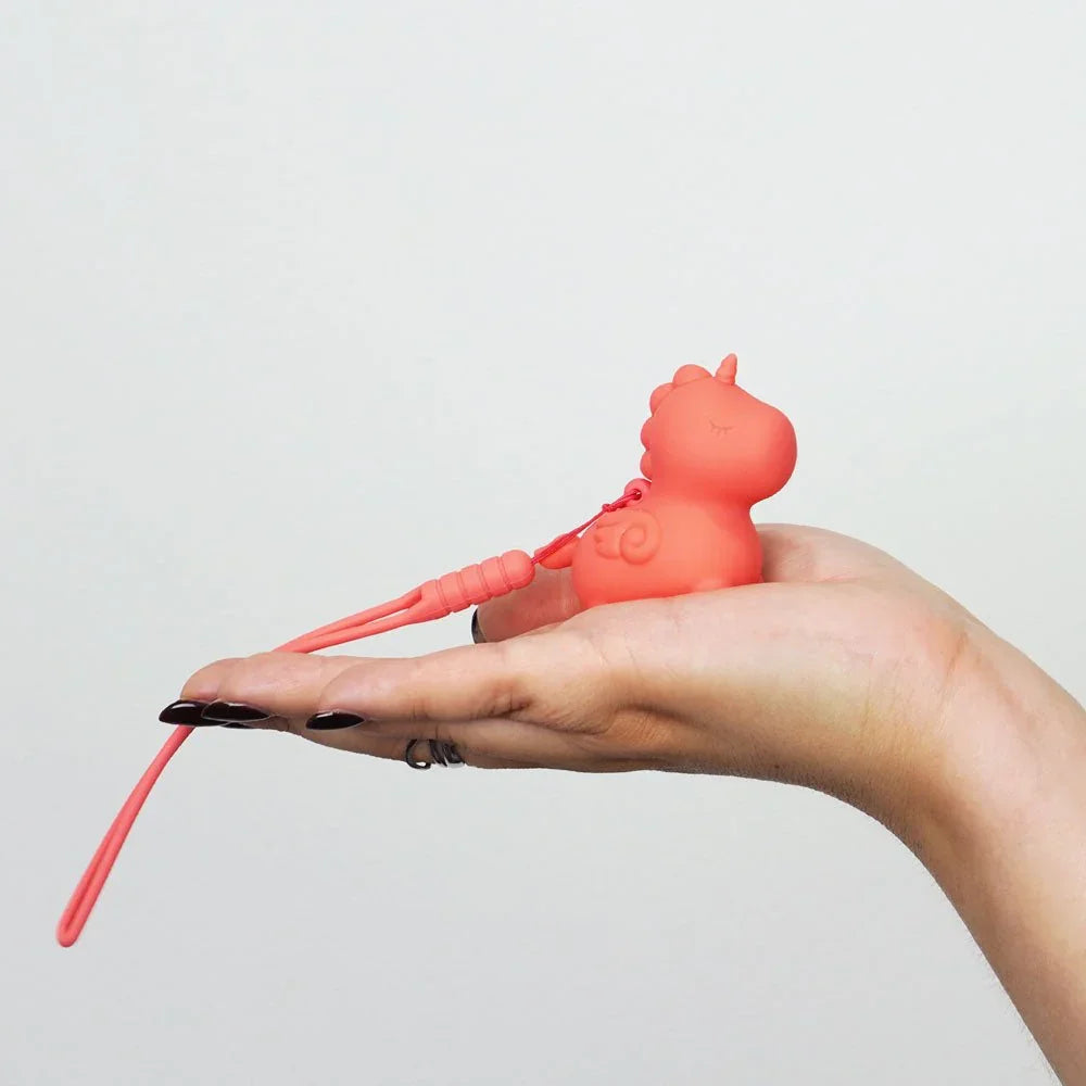 Peachy Pony resting on an open palm, keychain rein draped over