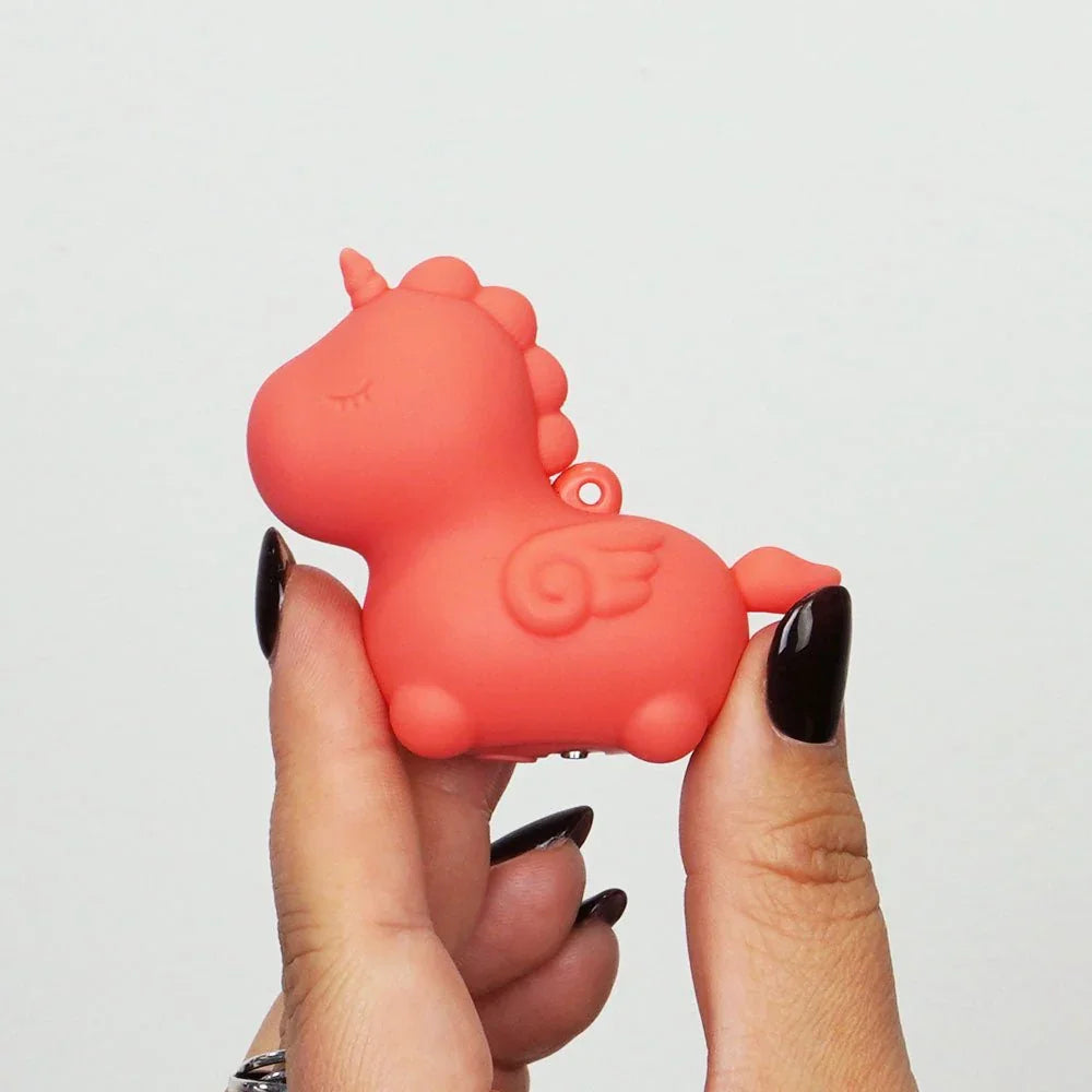 Peachy Pony mini vibe in Peach held on fingertips, wing detail showing