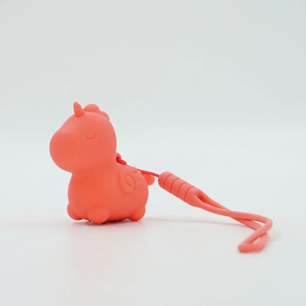Peachy Pony on white with its coral silicone keychain rein trailing