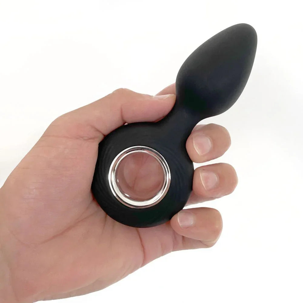 VERS Plug Vibe held in a hand, finger through the silver-lined ring handle