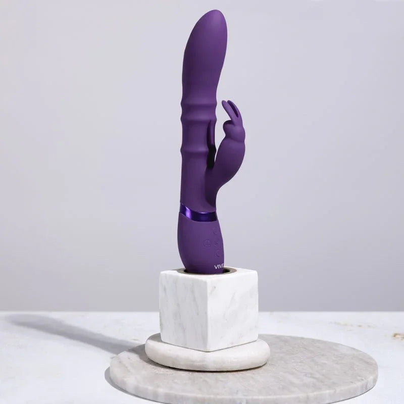 VIVE Sora Rabbit Vibrator in Purple, standing upright on a marble block in a styled setting