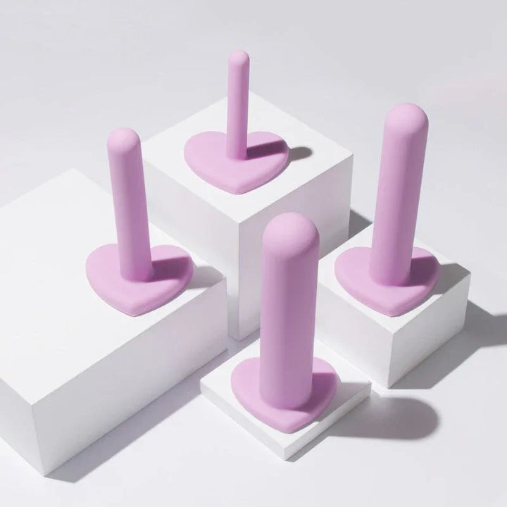 Four lilac Wellness dilators standing on white display blocks at different heights